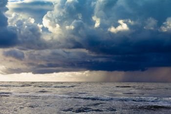 Evening seascape. Beginning of the storm rain in ocean, dark cloudy sky. Beginning of the storm rain in ocean, dark cloudy sky