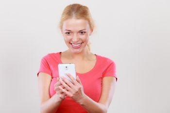 Fun with technology, modern devices concept. Attractive, smiling, happy excited blonde woman checking social media on smartphone.. Excited, happy blonde woman using smartphone