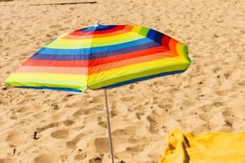 Beach objects and accessories concept. Colorful summer umbrella parasol during summertime weather.. Colorful summer umbrella parasol during summertime