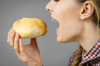 Woman holding bun bread roll enjoying her healthy morning breakfast. Wheat food.. Woman holding bun bread