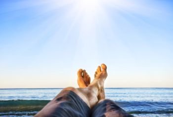 Legs on beach under the bright sun shot with selective focus. Legs on beach under the bright sun