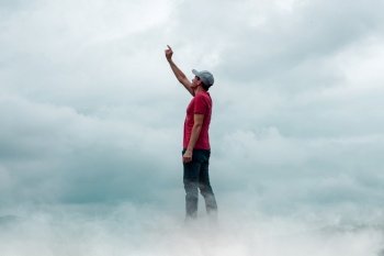 man portrait gesturing in the sky and clouds