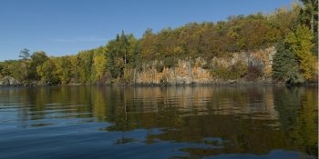 Reflection of trees along coastline, Kenora, Lake of The Woods, Ontario, Canada
