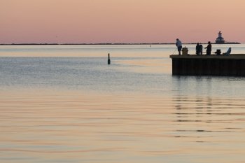 Tourists fly-fishing on pier at sunset, Spinnakers Landing, Summerside, Prince Edward Island, Canada