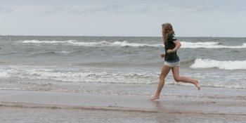 Girl running on the beach, Prince Edward Island, Canada