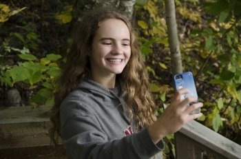 Girl taking selfie with a smartphone, Lake of the Woods, Ontario, Canada