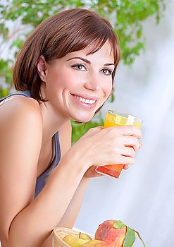 Portrait of beautiful happy brunette woman drinking tasty fresh juice on at home, having breakfast, organic nutrition, healthy lifestyle concept