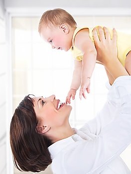 Happy mother and baby portrait, parents playing with a kid, having fun at home, healthy family enjoying life, parenting lifestyle