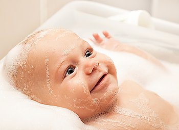 Little baby taking bath, closeup portrait of smiling boy, health care and hygiene concept