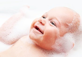 Little baby taking bath, closeup portrait of smiling boy, health care and hygiene concept