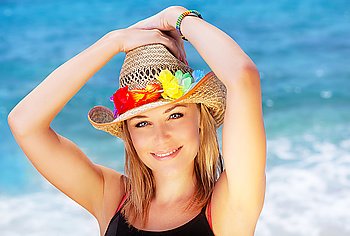 Beautiful female outdoor portrait over blue beach water, happy smiling face, summer fun concept
