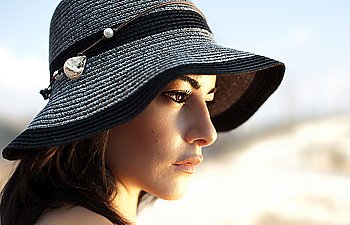 Photo of beautiful woman in black stylish hat, closeup portrait of gorgeous young lady with naturel makeup, side view of lovely charming arabic female, vacation and holiday concept