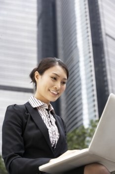 Chinese Businesswoman Working On Laptop Outside Office