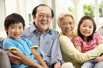 Portrait Of Chinese Grandparents With Grandchildren Relaxing At Home Together