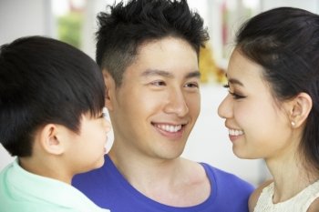Head And Shoulders Portrait Of Chinese Family Together At Home