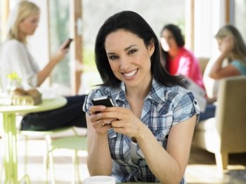 Woman Sending Text Message In Cafe