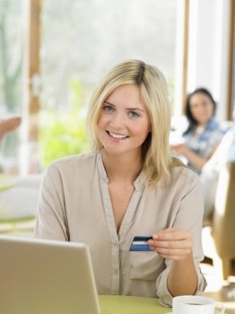 Woman Making Online Purchase In Cafe