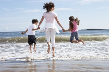 Mother And Children Having Fun On Beach Holiday