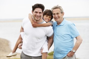 Male Members Of Multi Generation Family Standing By Sea
