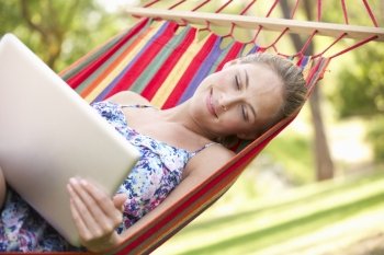 Woman Relaxing In Hammock With Laptop