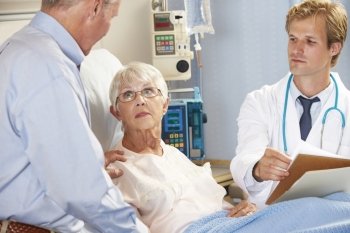 Doctor Talking To Senior Couple On Ward