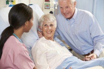 Nurse Talking To Senior Couple On Ward