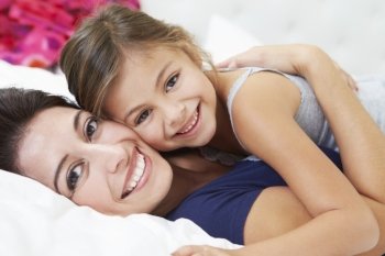 Mother And Daughter Lying In Bed Together