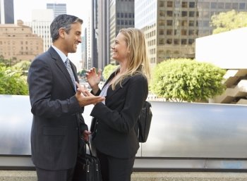 Businessman And Businesswoman Talking Outside Office