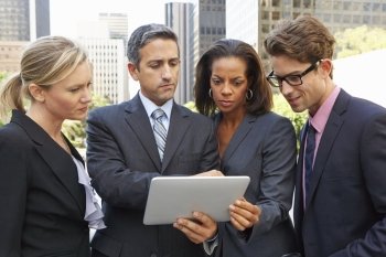 Businessmen And Businesswomen Using Digital Tablet Outside
