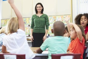 Teacher Talking To Elementary Pupils In Classroom