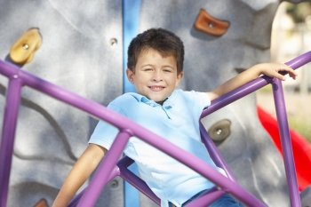 Boy On Climbing Frame In Park