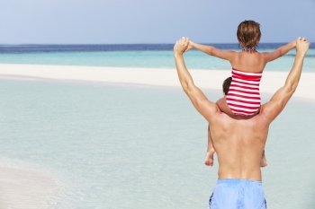 Rear View Of Father Carrying Daughter On Beach Holiday