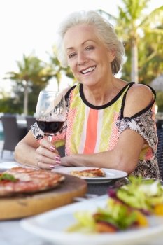 Senior Woman Enjoying Meal In Outdoor Restaurant