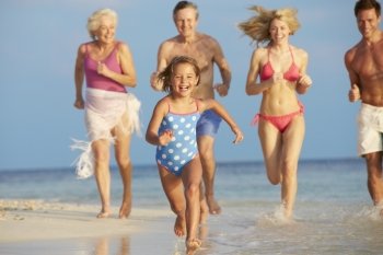 Multi Generation Family Having Fun In Sea On Beach Holiday