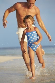 Father And Daughter Having Fun In Sea On Beach Holiday