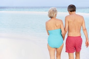 Rear View Of Senior Romantic Couple Walking In Tropical Sea