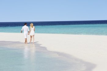 Rear View Of Romantic Couple Walking On Tropical Beach
