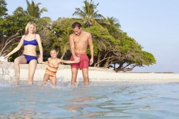 Family Splashing In The Sea On Tropical Beach Holiday
