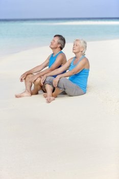 Senior Couple In Sports Clothing Relaxing On Beautiful Beach