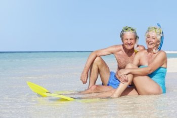 Senior Couple With Snorkels Enjoying Beach Holiday
