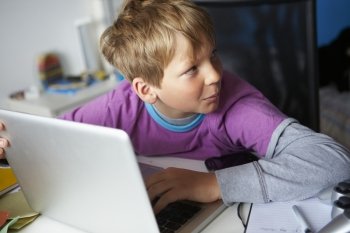 Boy Behaving Suspiciously Whilst Using Laptop