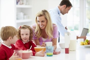 Family Having Breakfast In Kitchen Before School And Work