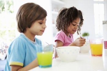 Two Children Having Breakfast In Kitchen Together