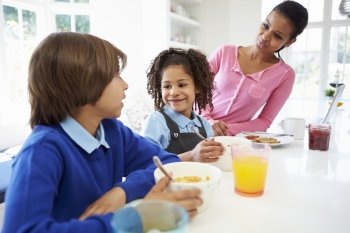 Mother And Children Having Breakfast Before School