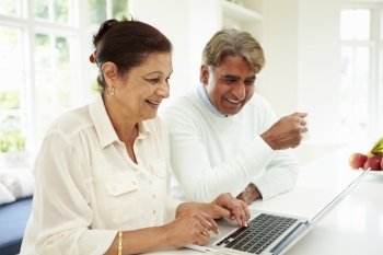 Senior Indian Couple Using Laptop At Home