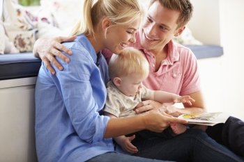 Parents Reading Book To Young Son
