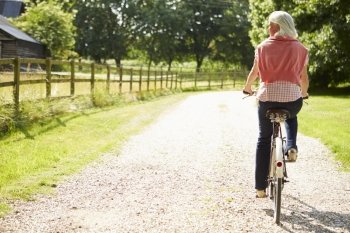 Middle Aged Woman Enjoying Country Cycle Ride