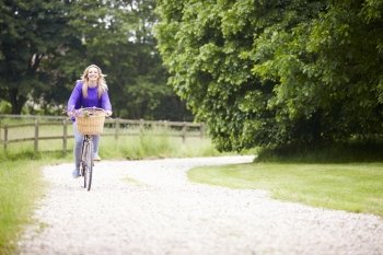 Teenage Girl Riding Bike Along Country Lane