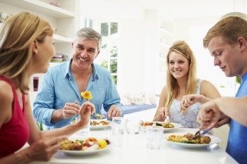 Family With Teenage Children Eating Meal At Home Together