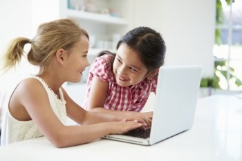 Two Young Girls Using Laptop At Home